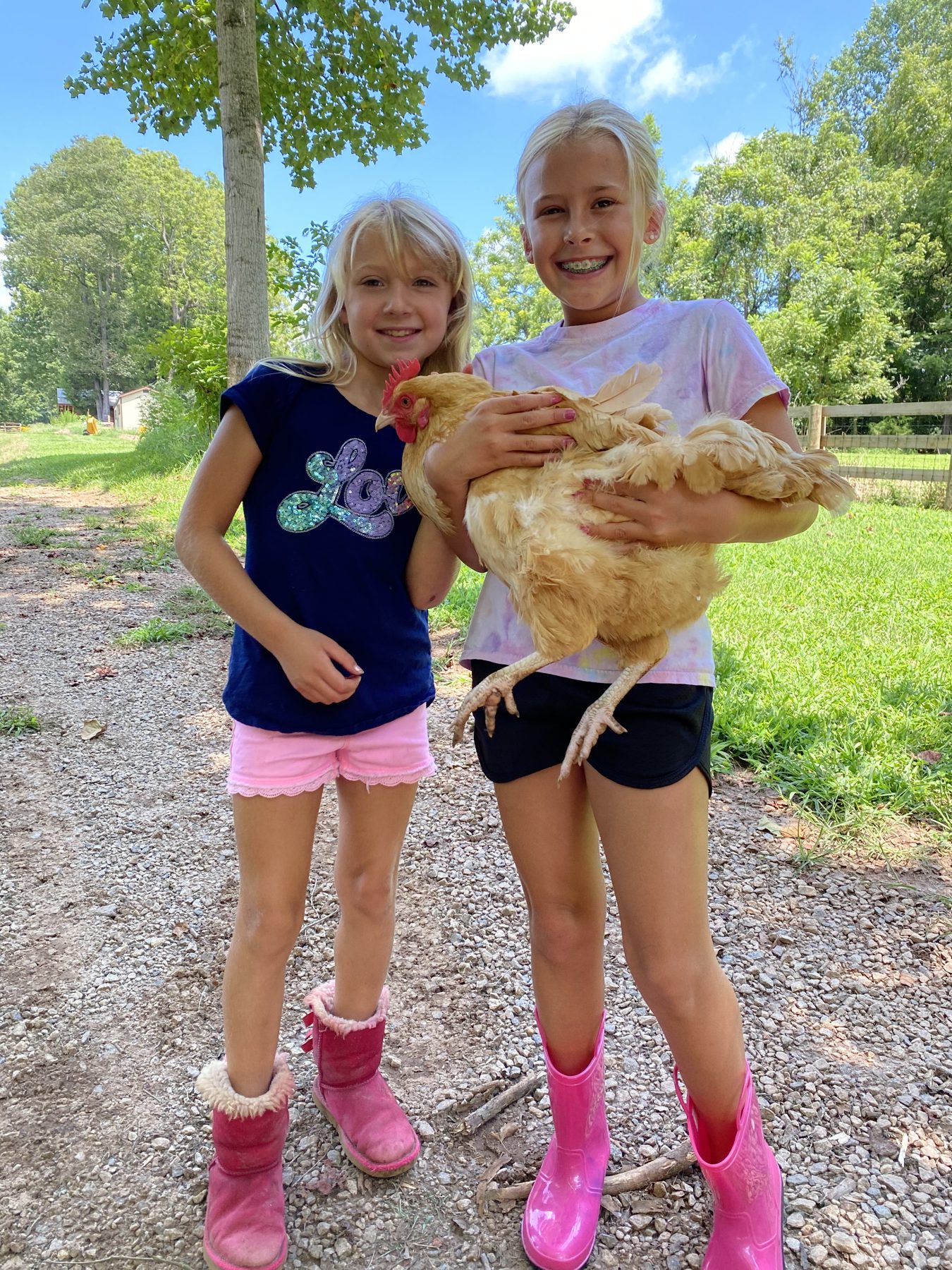 Two campers holding a chicken