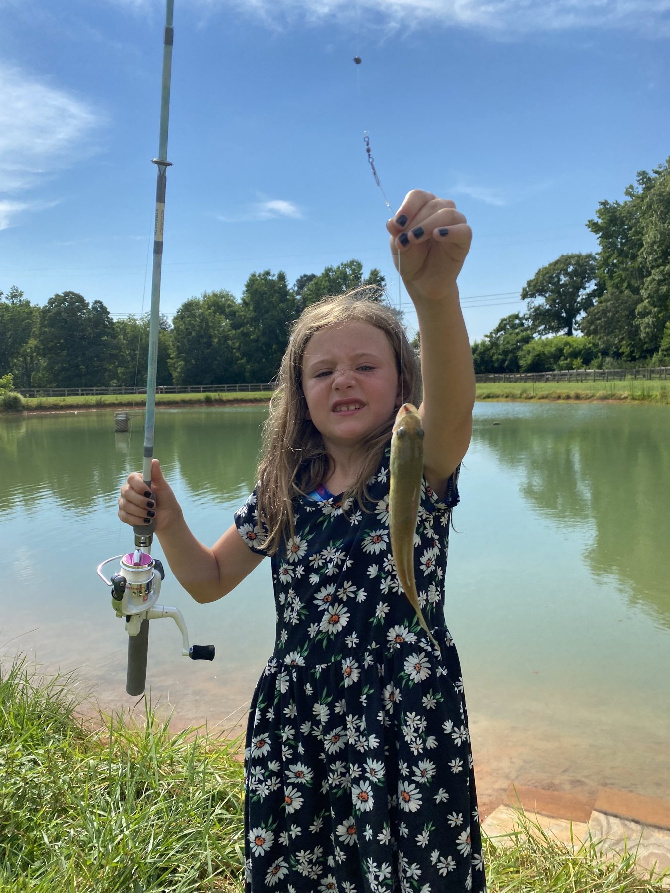 A camper showing off a fish caught at the pond